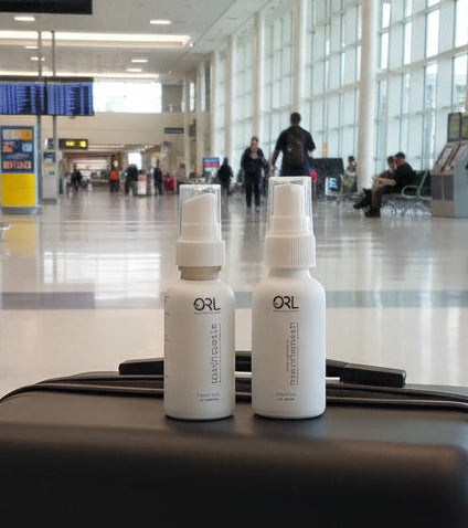 Two ORL bottles on a suitcase in an airport terminal.