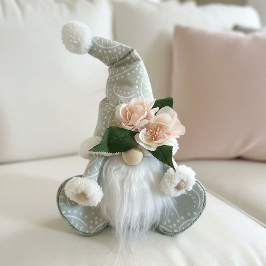 Decorative gnome with flowers on a light-colored surface