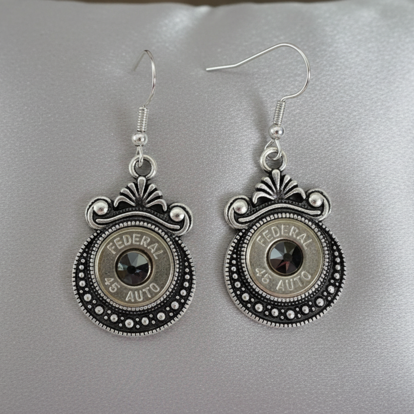Silver bullet casing earrings on a wooden surface