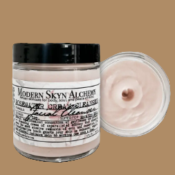Jar of Modern Skin Alchemy facial cleanser with a close-up of the product on a wooden surface.