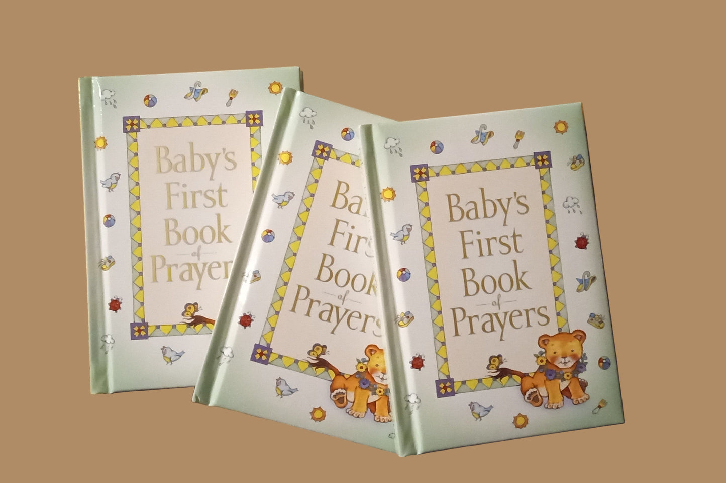 Three baby books with a teddy bear design on a textured surface