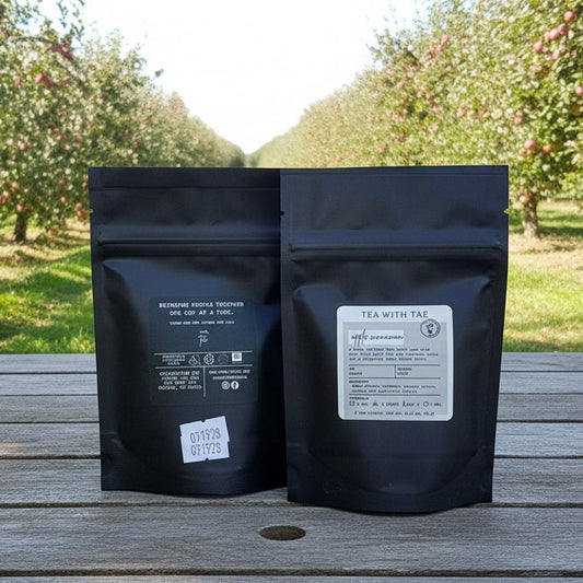 Two black coffee bags with labels on a reflective surface.