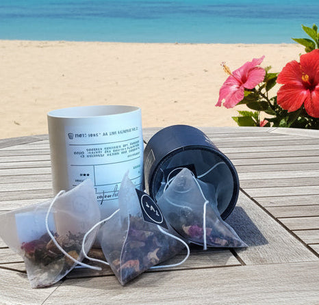 Round wooden table with a candle and flowers on a sandy beach with ocean view