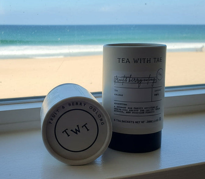 Two cylindrical containers labeled 'TWT' on a wooden surface.