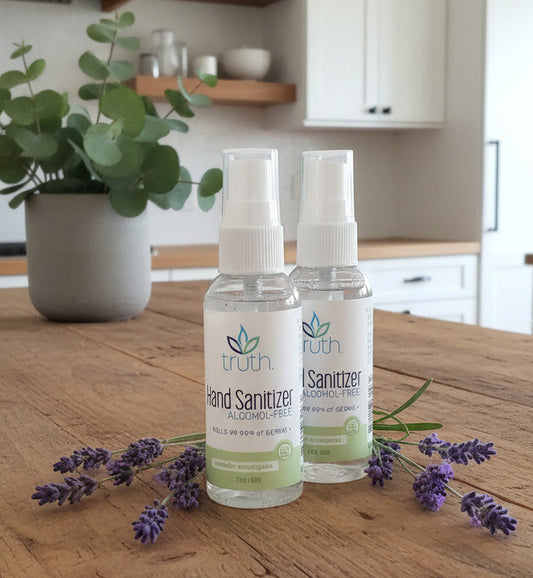 Two bottles of hand sanitizer on a dark surface with a blurred background