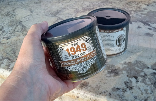 Hand holding a container labeled '1949' on a textured surface