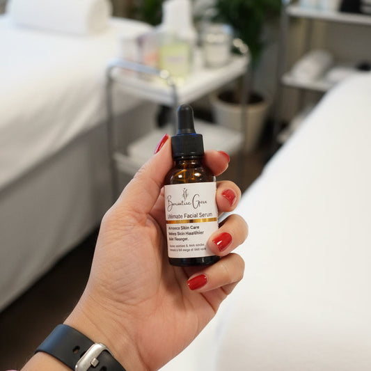 Hand holding a small brown bottle with a dropper labeled 'The Organic Skin Care' in an indoor setting.
