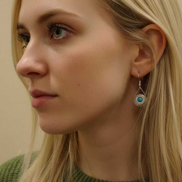 Close-up of a person's ear with a visible earring against a neutral background