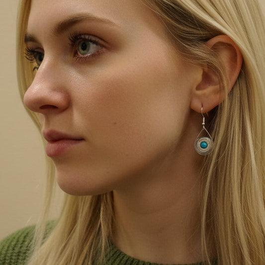 Close-up of a person's ear with a visible earring against a neutral background