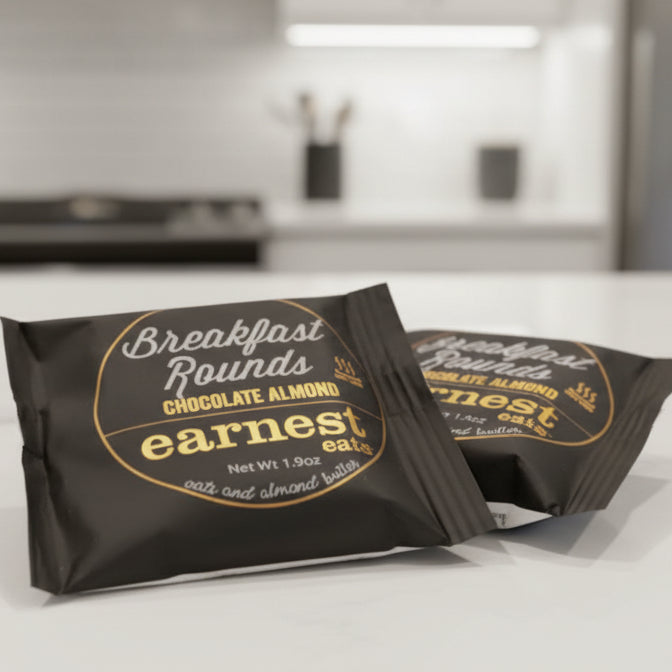 Two packages of 'Earnest Eats' breakfast rounds on a dark surface