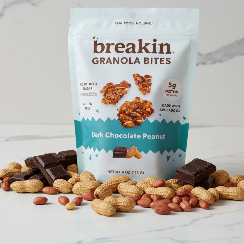 Two packages of 'breakin granola bites' on a dark surface