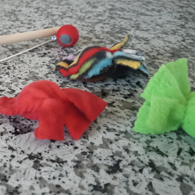 Toy wooden fishing pole and colorful fabric magnetic fish.