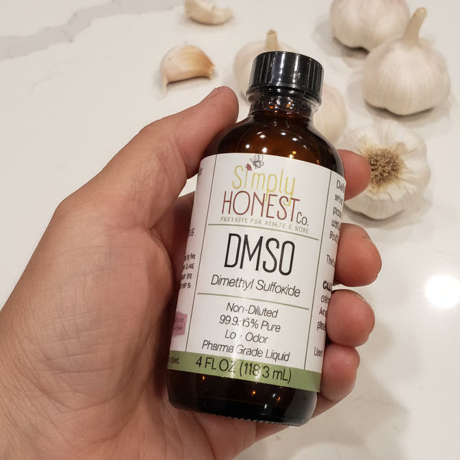 Hand holding a bottle labeled 'Rhone' on a dark surface