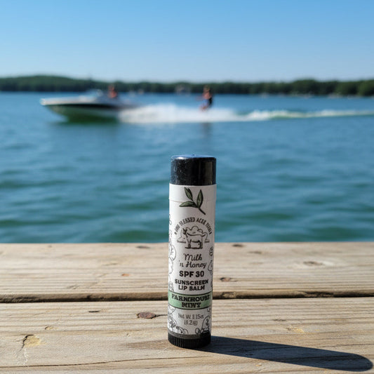 Lip balm on a wooden dock with a lake and boat in the background