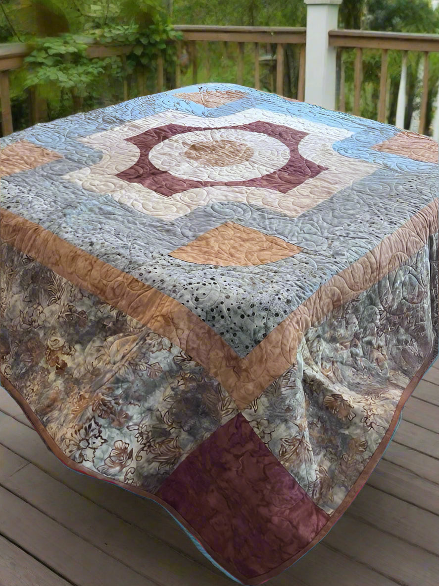 Quilt with a geometric pattern on a wooden surface outdoors