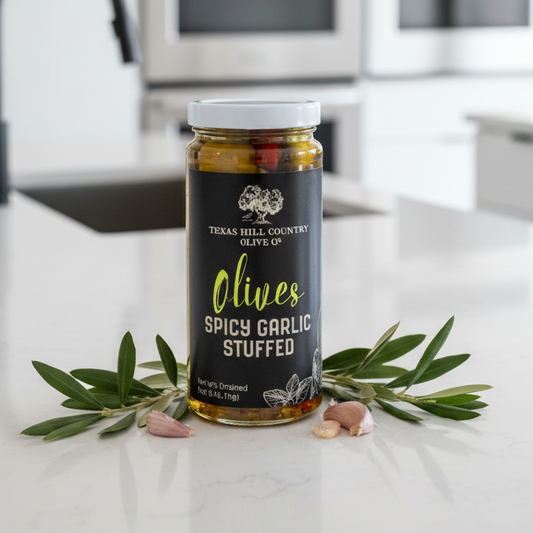 Jar of spicy garlic stuffed olives on a black background