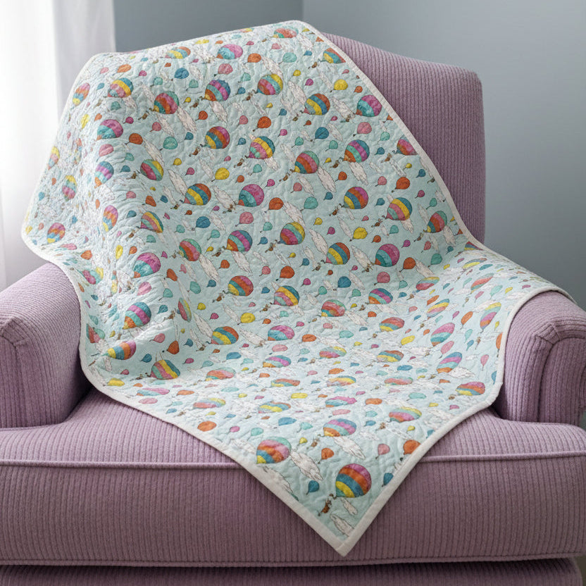 Baby blanket with colorful elephant pattern on a wooden surface