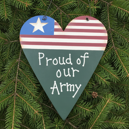 Heart-shaped wooden sign with American flag design and 'Proud of our Army' text on a concrete surface.