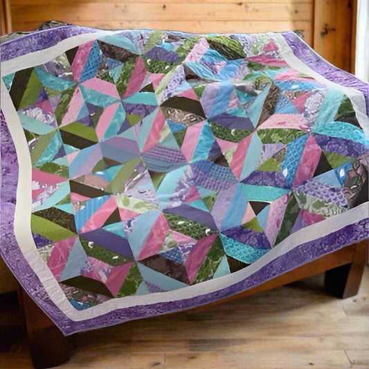 Colorful quilt with geometric pattern draped over a chair.