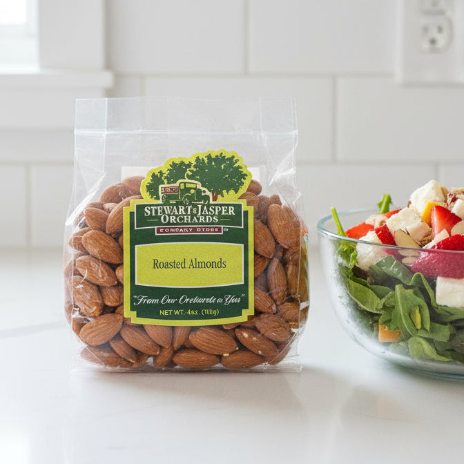 Packaged almonds next to a salad on a kitchen counter