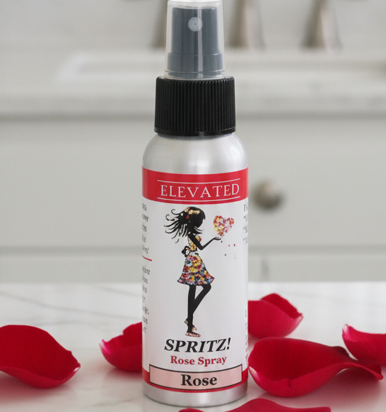 Spray bottle labeled 'Sprite' with red rose petals on a white surface