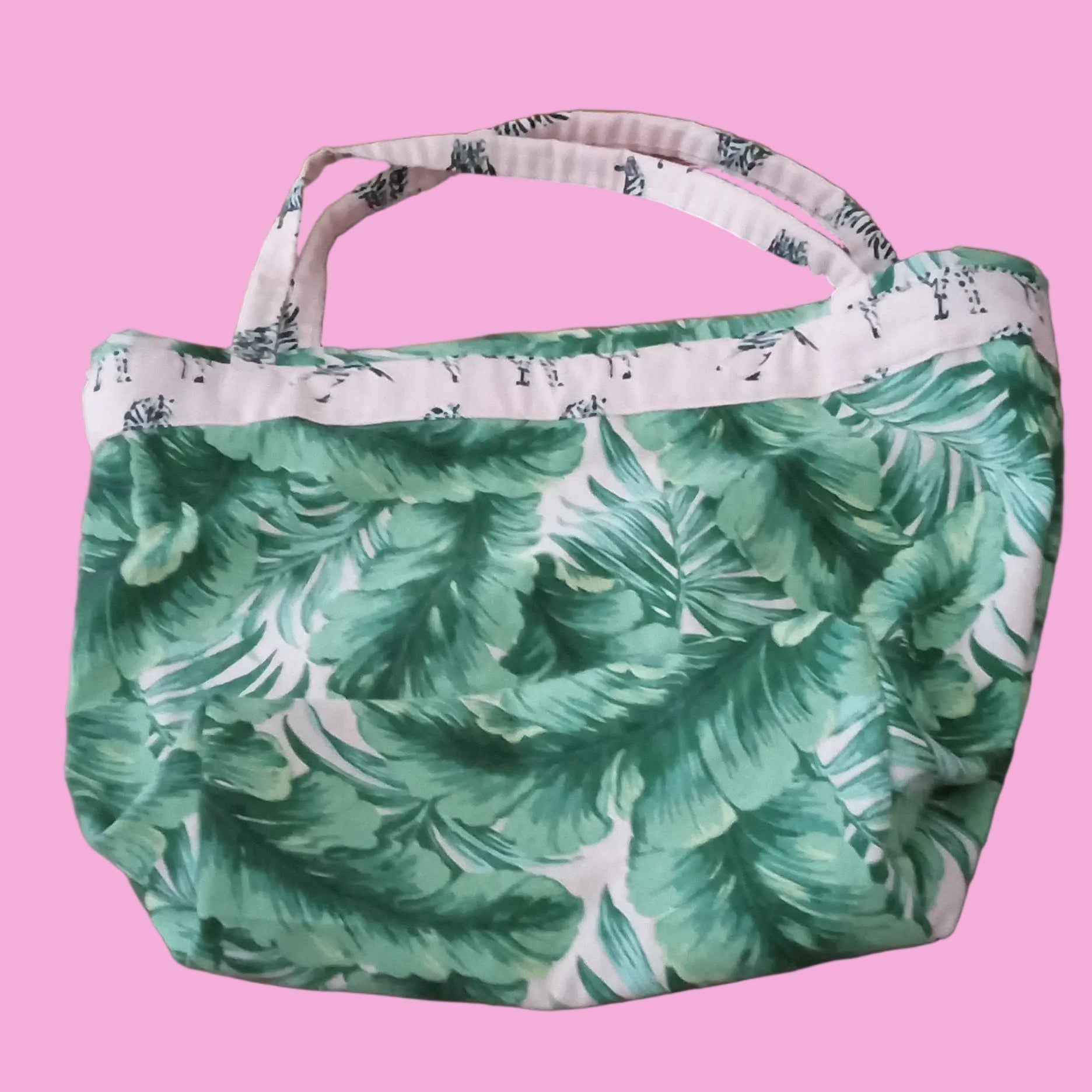 Green leaf-patterned bag on a wooden floor
