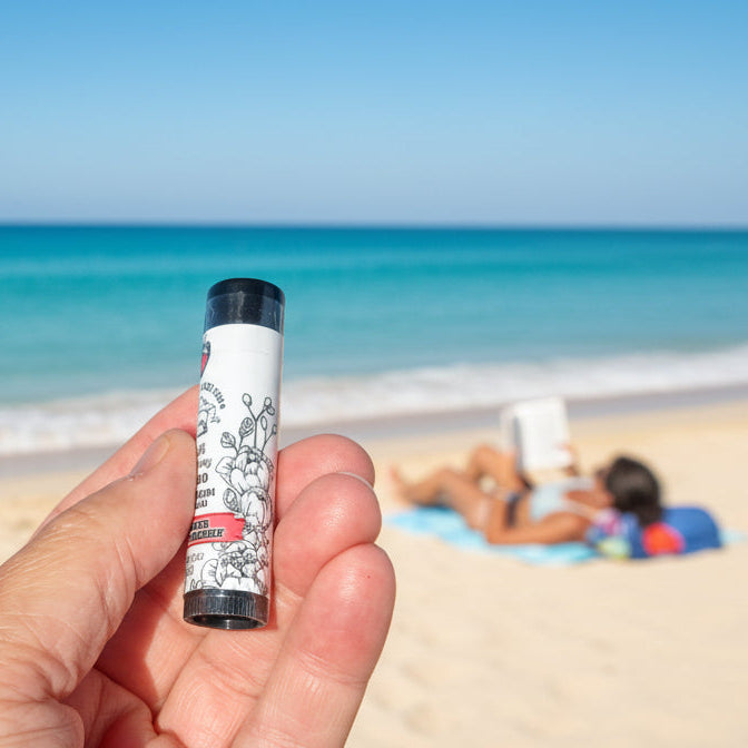 Hand holding a small cylindrical object with a black cap on a countertop.