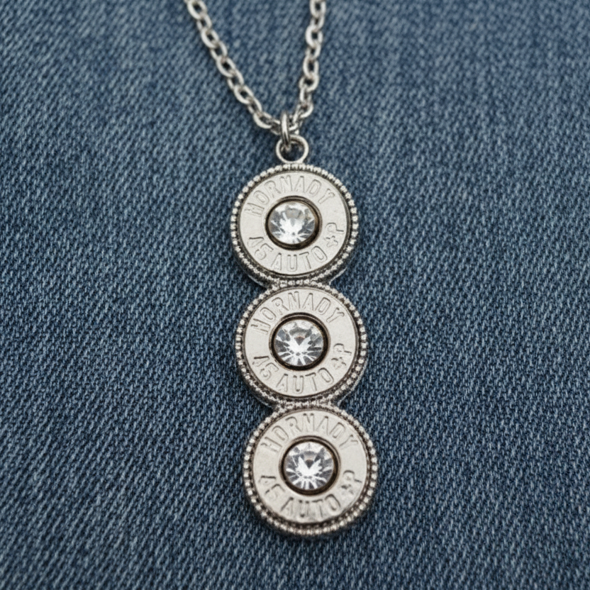 Silver necklace with three circular pendants on a stone surface