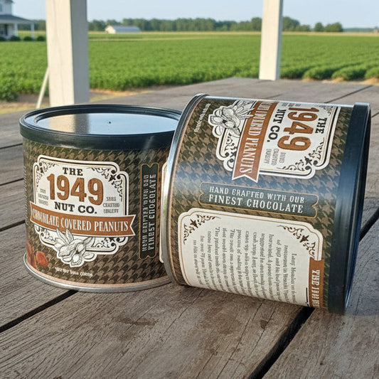 Two vintage-style metal cans on a wooden surface with a farm in the background