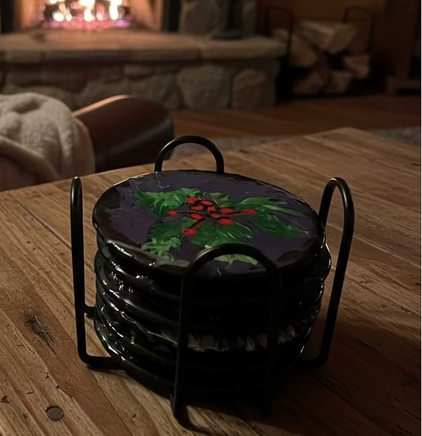 Decorative woven basket with floral design on a wooden table in front of a stone fireplace.