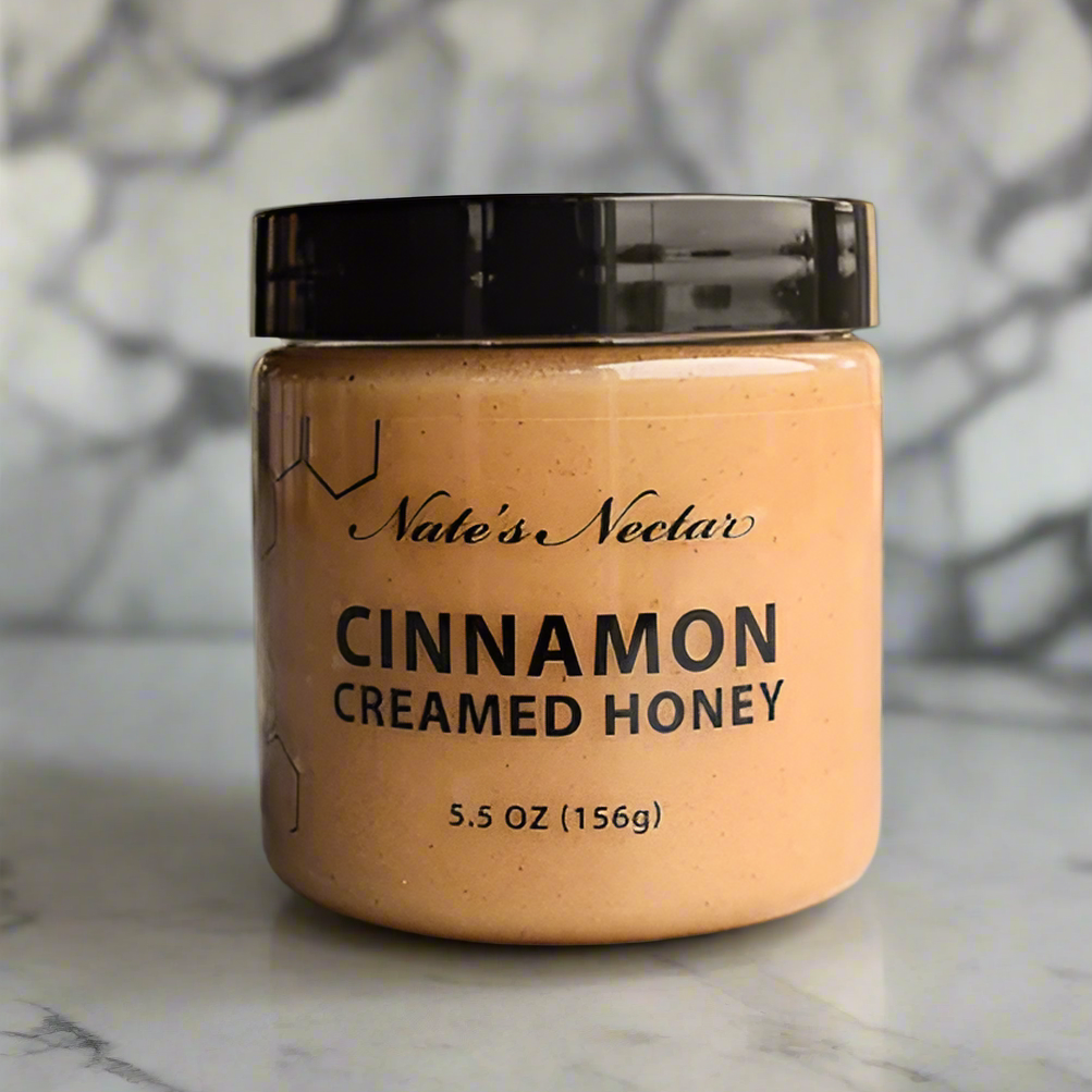 Jar of Nate's Nectar Cinnamon Creamed Honey on a textured surface