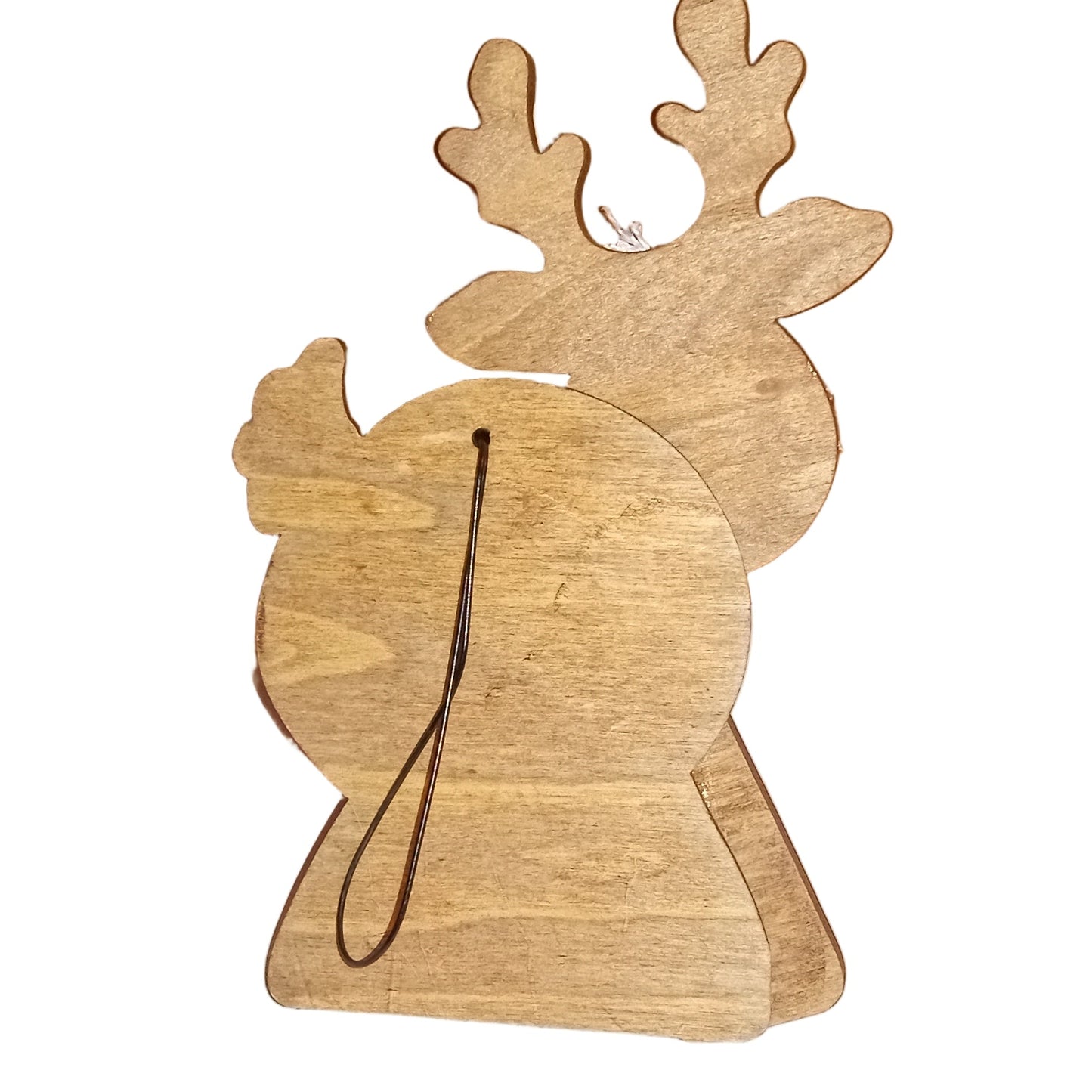Wooden reindeer ornament on a white surface with a brown box in the background