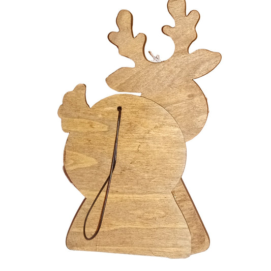 Wooden reindeer ornament on a white surface with a brown box in the background