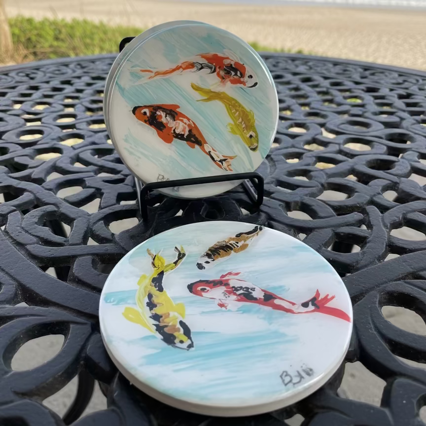 Set of round coasters with fish design on a white surface