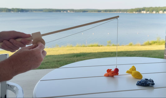 Colorful toy fish on a table with a brick wall background