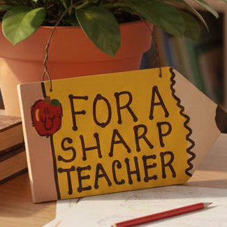 Two wooden signs with text and an apple graphic on a fabric background