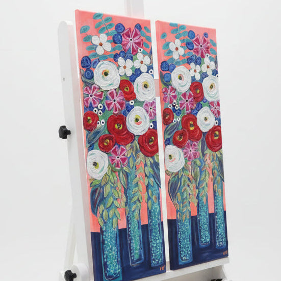 Colorful floral paintings on an easel in a studio setting
